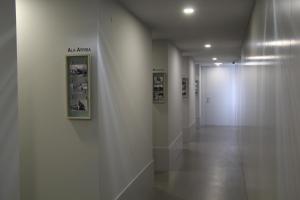 a hallway with a white wall with pictures on it at StayInn City - Póvoa de Varzim in Póvoa de Varzim