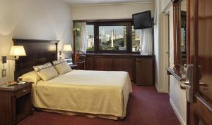 a hotel room with a bed and a window at Hotel Presidente Buenos Aires in Buenos Aires