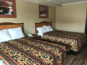 a hotel room with two beds and a telephone at Memphis Inn in Memphis