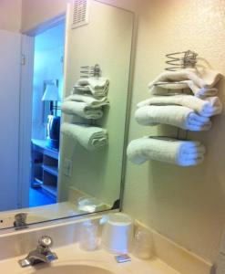 a bathroom with two sinks and a mirror at Hilltop Inn & Suites in Victorville