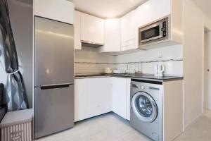 プラヤ・デル・イングレスにあるYumbo Movida Accommodationの白いキッチン(洗濯機、電子レンジ付)