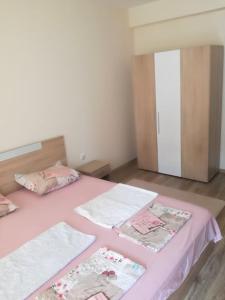 a bedroom with a pink bed with towels on it at My cosy place in Burgas
