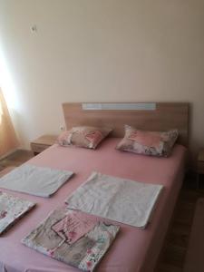 a bedroom with two beds with pink sheets and pillows at My cosy place in Burgas