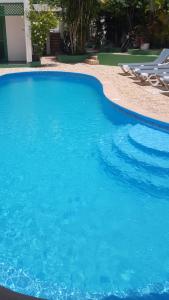 a large blue swimming pool with some chairs in it at Terraza del Caribe in Boca Chica