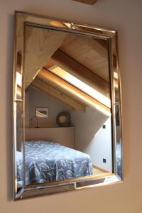 un riflesso a specchio di un letto in una stanza di La Basiglia Apartment a Monforte dʼAlba