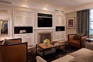 a living room with a fireplace and a tv at The Peninsula New York in New York