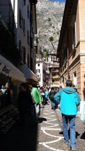 Un gruppo di persone che camminano per una strada cittadina di Mansarda Ariel a Limone sul Garda