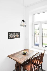 Una mesa de comedor con dos sillas y una ventana. en Ronus Apartments Łódź Pomorska 116 -Bezpłatny Parking, en Łódź