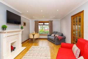 a living room with a fireplace and a tv at Lomond Serviced Apartments- Inglewood in Alloa
