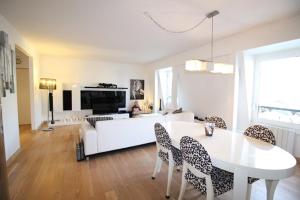 a living room with a white couch and a table and chairs at Appartements à Deauville dans Triangle d'Or in Deauville