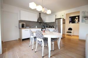 a kitchen with a white table and chairs in a room at Appartements à Deauville dans Triangle d'Or in Deauville