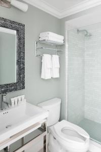 a bathroom with a toilet and a glass shower at The Sydney, The Edgartown Collection in Edgartown