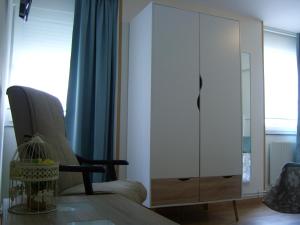 a living room with a white cabinet and a chair at PR Tambre in Santiago de Compostela