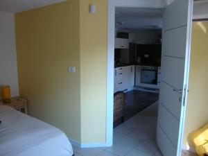 Habitación con cama y cocina con armarios blancos. en Apartments Ilona, en Novi Vinodolski