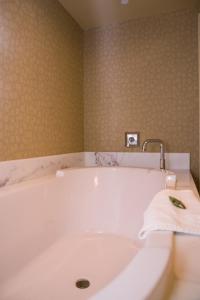 bañera blanca con grifo en el baño en Isle Casino Hotel Bettendorf, en Bettendorf