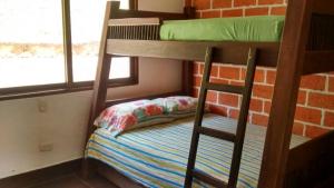a bunk bed with a pillow and a chair in a room at CASA CAMPESTRE MONTECARLO Guatapé- desayuno a pareja in Guatapé