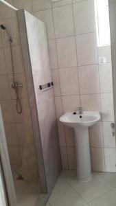 ein Bad mit einem Waschbecken und einer Dusche in der Unterkunft Mazury apartament in Woźnice