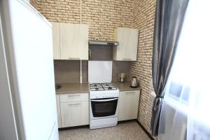 a small kitchen with a stove and white cabinets at Мини-отель Герцено in Moscow