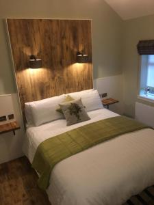 a bedroom with a large bed with a wooden headboard at Rosemount Boutique B&B in Lanark