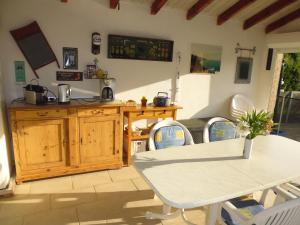 eine Küche und ein Esszimmer mit Tisch und Stühlen in der Unterkunft Villa mit grosser Sommerküche und Pool, 8 Minuten zum Sandstrand Cap Sud in LʼArena