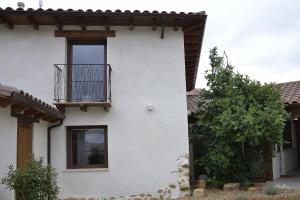 ein weißes Haus mit einem Balkon an der Seite in der Unterkunft El Vallín de Lan in Cerezales del Condado