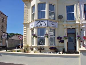 a white building with a sign on the front of it at The Harbour Inn B&B Larne in Larne