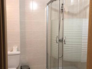 uma casa de banho com uma cabina de duche em vidro e um WC. em Apartamenti Eli em Pomorie