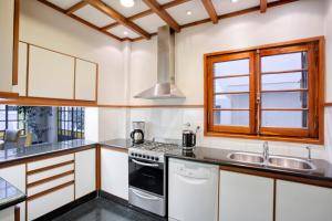una cocina con electrodomésticos blancos y una ventana en Casa Sur - 500 m from the park at the greenest and most elegant neighbourhood en Mendoza