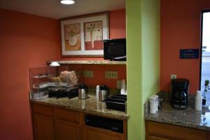uma cozinha com paredes cor de laranja e uma bancada em Apex Inn em Modesto