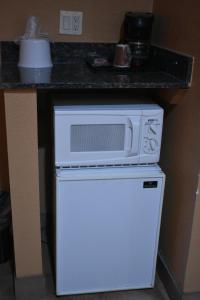 a microwave on top of a refrigerator in a kitchen at Apex Inn in Modesto