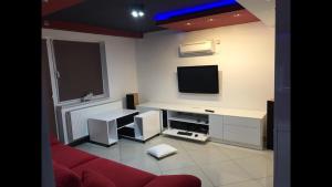 a living room with a red couch and a flat screen tv at Korona Panzió in Balog nad Ipľom