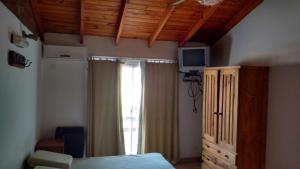 1 dormitorio con 1 cama, vestidor y ventana en Andalhue 2 en Playas Doradas