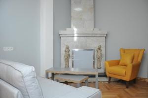 a living room with a couch and a table and a chair at Palm Hotel in Batumi