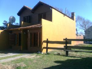 una pequeña casa con una valla delante de ella en Ramita-Costa Azul en San Bernardo
