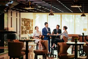 a group of people sitting at tables in a restaurant at Barceló Mexico Reforma in Mexico City
