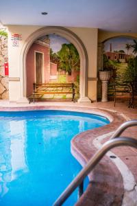 a large swimming pool in a building with an outdoor at Hotel Colonial de Merida in Mérida