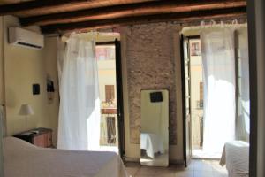 een slaapkamer met 2 bedden en 2 glazen schuifdeuren bij Sant Efisio Host in Cagliari