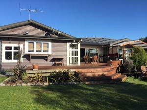 a house with a deck and a patio at Adventure B&B in Takaka