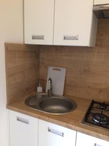 a kitchen counter with a sink and a stove at Apartament Fibra Latte in Rybnik