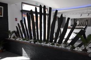 a wooden fence with plants on a brick wall at The Originals City, Hôtel des Arts, Montauban (Inter-Hotel) in Nègrepelisse