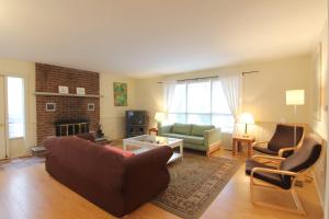 a living room with a couch and chairs and a fireplace at Birch Cliff Lodge on Baptiste Lake in Bancroft