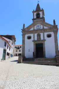 una iglesia con una torre de reloj en una calle empedrada en Casa Cimo Vila en Provesende