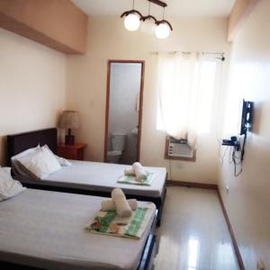 two beds in a room with two towels on them at AAM Transient and Guest House in Manila