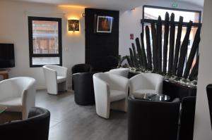 a waiting room with white chairs and a table at The Originals City, Hôtel des Arts, Montauban (Inter-Hotel) in Nègrepelisse