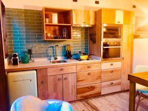 una cocina con armarios de madera y una pared de azulejos azules en DT Loft en Puerto Natales