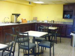 a restaurant with tables and chairs in a kitchen at Park Hill Inn and Suites in Oklahoma City