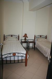 - 2 lits dans une chambre avec 2 tables dans l'établissement Appartement de Mustapha larache, à Larache