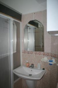 La salle de bains est pourvue d'un lavabo et d'un miroir. dans l'établissement Appartement de Mustapha larache, à Larache