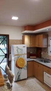 a kitchen with a white refrigerator with an orange on it at TuHabitat BA in Villa Adelina