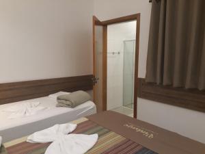 a hotel room with two beds and a mirror at Hotel Vintage in Assis